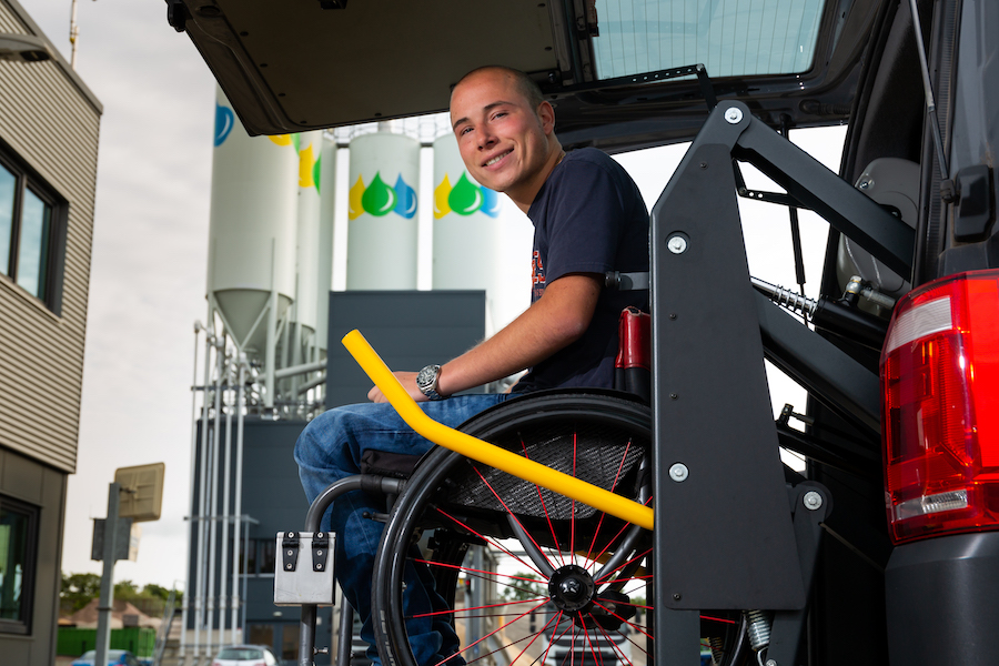 Medewerker die rolstoel gebruikt krijgt hulp bij vervoer